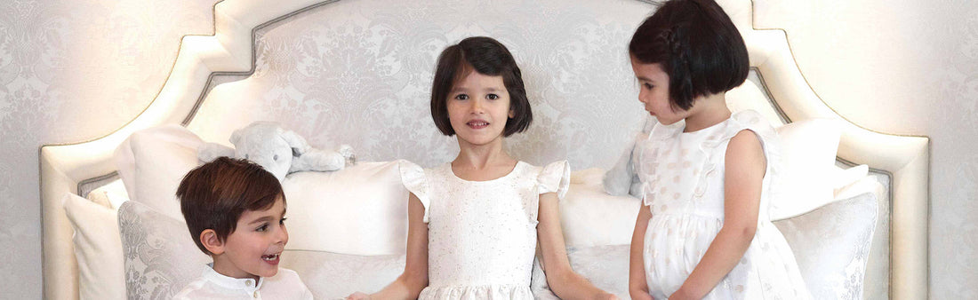 Trois enfant sont sur un lit de l'hôtel George V